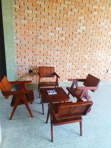 a group of benches and tables in front of a brick wall at The Kheak in Weligama