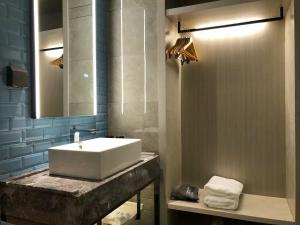 a bathroom with a white sink and a mirror at Echarm Hotel - Wuhan University Hongshan Square Metro Station in Wuhan