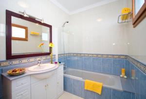 łazienka z wanną, umywalką i lustrem w obiekcie Grand Villa Famara Puerto del Carmen w Puerto del Carmen