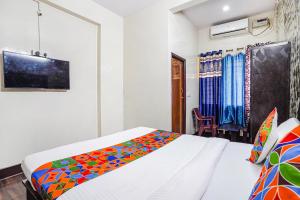 a bedroom with a bed with a colorful blanket at FabExpress Pavithraa Edition - Nr Yeshwantpur Circle in Bengaluru