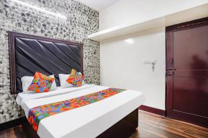 a bedroom with a large bed with colorful pillows at FabExpress Pavithraa Edition - Nr Yeshwantpur Circle in Bengaluru
