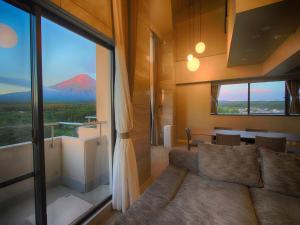sala de estar con sofá y vistas a la montaña en Hotel Regina Kawaguchiko, en Fujikawaguchiko