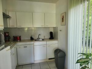 a small kitchen with white cabinets and a sink at Sleepspot Wedde in Wedde