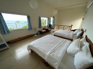 una camera da letto con due letti e vista sull'oceano di Sun Motel a Chenggong
