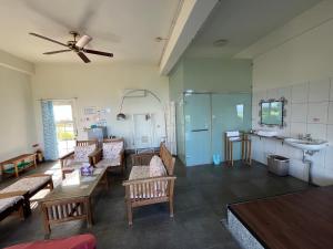 un soggiorno con panchine, lavandino e ventilatore a soffitto di Sun Motel a Chenggong