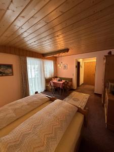 a bedroom with a large bed and a table at Landhaus Zwanzleitner in Filzmoos