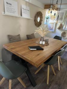 a wooden table with chairs and a laptop on it at Ferienhaus Sauerland - Traum in Winterberg