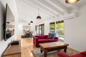 a living room with a red couch and a table at Retreat on Red Rocks in Cowes