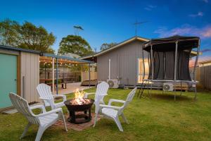a group of chairs around a fire pit in a yard at Retreat on Red Rocks in Cowes