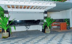 a pavilion with a bench and plants in a patio at Villa Exora Pasikudha in Batticaloa