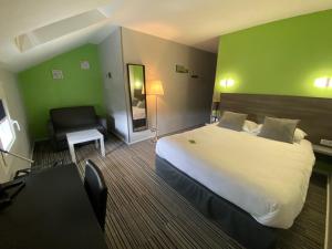 een hotelkamer met een groot bed en een stoel bij Hôtel Bagatelle in Pont-à-Mousson