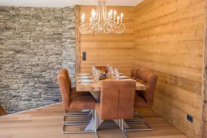 a dining room with a table and leather chairs at Luxus Ferienwohnung Almhütte in Brixen im Thale