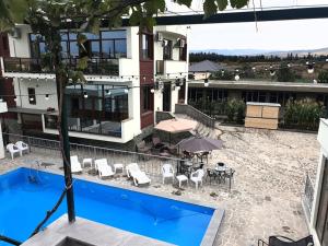 a building with a pool and a table and chairs at Dreamvilla tbilisi hotel in Tbilisi City +13 photos