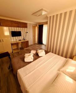 a hotel room with two beds and a television at Dreamvilla tbilisi hotel in Tbilisi City