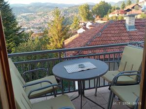 a table and chairs on a balcony with a view at Apartments Amy in Sarajevo