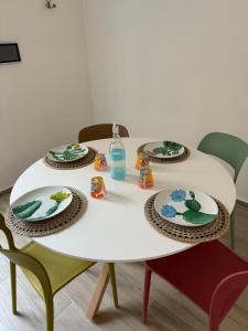 Montalbano IonicoCasa Vacanza Pitagora的一张带两把椅子和盘子的白色桌子