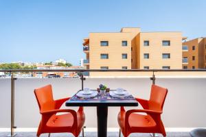 a table and chairs on a balcony with a view of a building at Tropikana Paradise Miami in Miami Platja