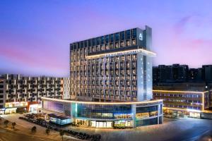 a large building with lights on in a city at night at Atour Hotel Guangzhou Baiyun Station Julong Metro Station in Guangzhou