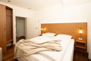 a bedroom with a large white bed with a wooden headboard at das zellersee in Zell am See