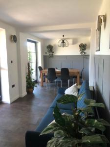 a living room with a blue couch and a table at Bella Villa in Balatonalmádi