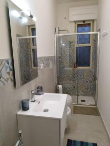 a bathroom with a white sink and a shower at Villetta Le Cesine in Torre Specchia Ruggeri