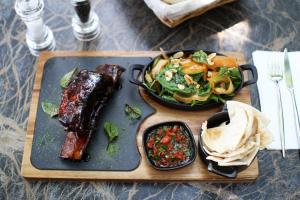 a tray with meat and a salad and a plate of food at Hotel Privighetoarea in Slobozia