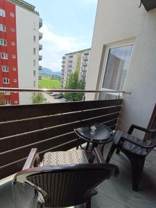 a balcony with two chairs and a table on it at DAR Residence in Braşov
