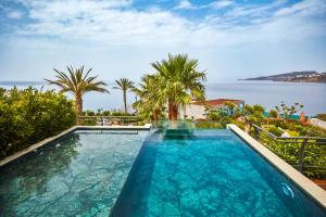 a swimming pool with a view of the ocean at Root Redrock Yalıkavak in Yalıkavak