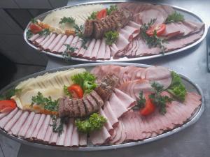 due padelle piene di carne e verdure su un tavolo di Willa Sport a Zakopane