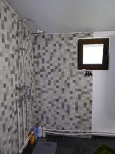 a bathroom with a shower with a tiled wall at Casa Valer Arieseni in Arieşeni