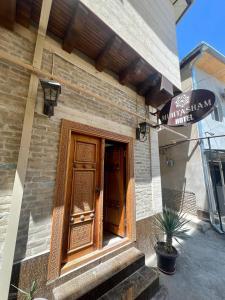 a building with a wooden door on the side of it at Muhtasham in Bukhara