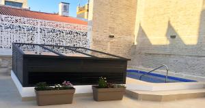 a building with two potted plants next to a hot tub at Feelathome Rivero Apartments in Seville +67 photos