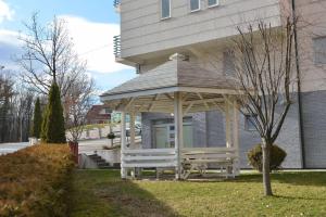 a wooden gazebo in front of a house at Studio apartman Zvezdana Noć in Vrnjačka Banja +4 photos