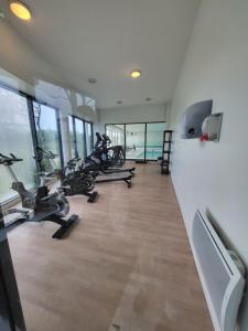 a gym with several treadmills and exercise bikes at Maison mer et piscine 3 nuits minimum in Loc-Maria-Plouzané