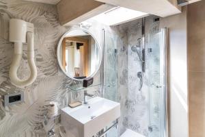 a bathroom with a sink and a mirror at Melody Hotel in Cervia