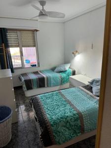 a bedroom with two beds and a desk and a window at Casa Schila in Tavernes de Valldigna +22 photos