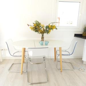 a white table with chairs and a vase with flowers at Apartament Sant Feliu de Guixols in Sant Feliu de Guixols +5 photos