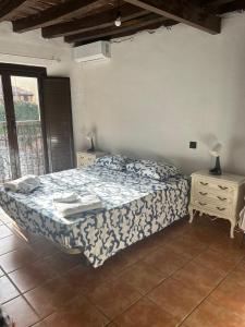 a bedroom with a bed and two night stands and a window at La Posada De Alanah in Candeleda