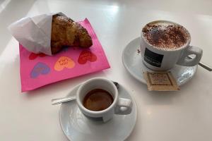 a table with two cups of coffee and a pastry at ALMA B&B Cosenza CENTRO in Cosenza