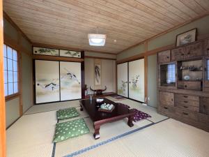 a living room with a couch and a table and windows at HOEI villas Fujisan全景 富士山 河口湖中心区 in Fujikawaguchiko