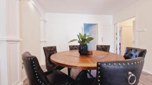 a dining room with a wooden table and leather chairs at Villa Ruths Stay Valta in Kouvola