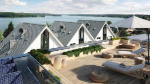 a house with a deck with a view of the water at Apartament z Tarasem na Dachu in Charzykowy