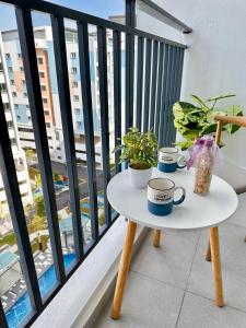 芙蓉Bayu Temiang Residensi的阳台上的桌子上放着杯子和植物 更多17张照片