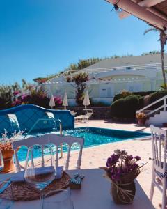 a table with chairs next to a swimming pool at Hotel Albatros in Ischia