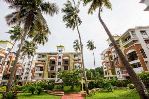 a row of palm trees in front of buildings at 2BHK -Balcony & Pool View -Monarch Palms, Cadolim in Candolim