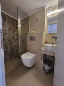 a bathroom with a toilet and a sink at Theros Summer Suite 1 in Nikiti +7 photos