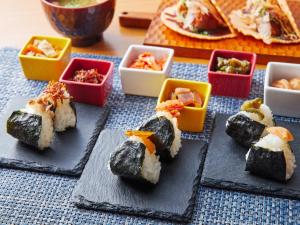 a group of sushi on a table with bowls of food at APA Hotel & Resort Osaka Namba Ekimae Tower in Osaka