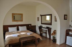 a bedroom with a bed and a desk and a mirror at Philoxenia in Kavála