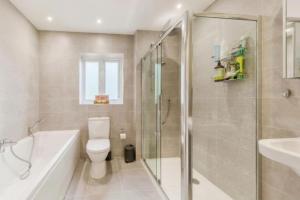 a bathroom with a toilet and a shower and a sink at Cheshire home by Chelsea in Macclesfield +12 photos