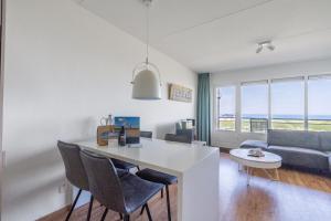 a kitchen and living room with a view of the ocean at Appartementencomplex Juliana 102 in De Koog